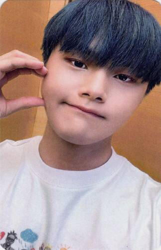 Photocard of Jahan making a half heart against his cheek