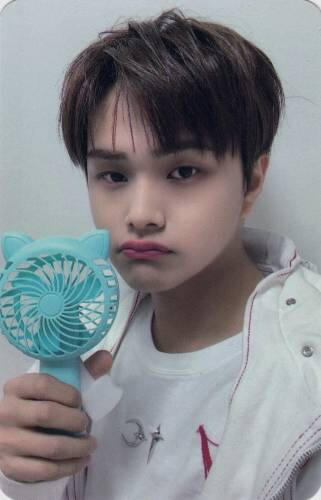 Photocard of Jahan pouting slightly while holding a blue fan with cat ears