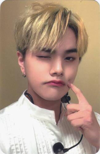 Photocard of Jahan in a white shirt with a black microphone, poking his cheek and winking