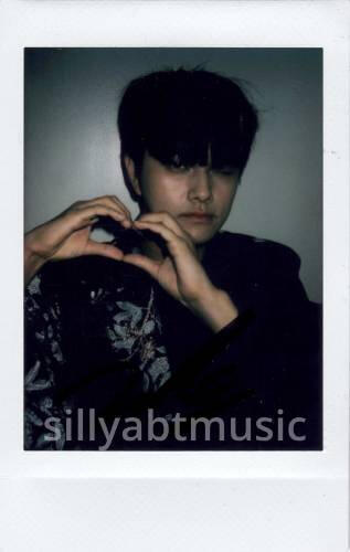 Polaroid of Jahan winking and making a hand heart