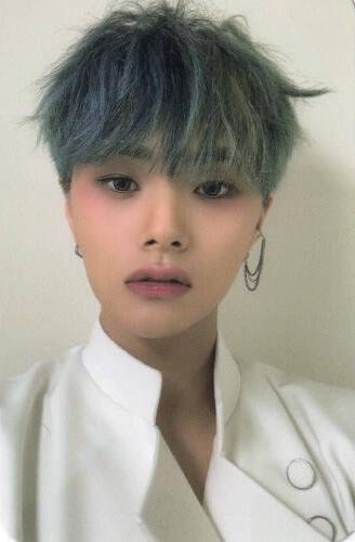 Photocard of Jahan wearing a slightly-open white coat and gazing into the camera