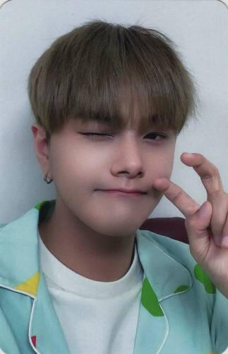 Photocard of Jahan wearing pajamas while winking and making a curled peace sign