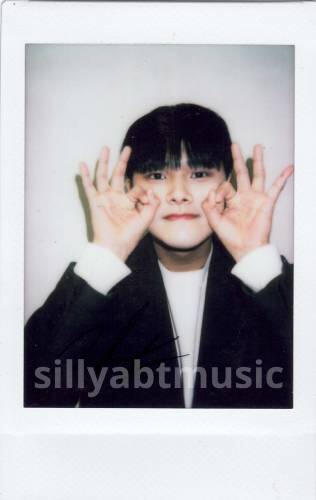 Polaroid of Jahan circling his cheeks and grinning