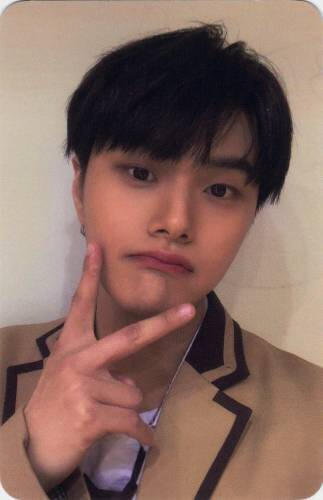 Photocard of Jahan in a tan blazer making a peace sign at his chin