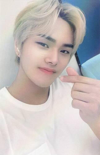 Photocard of Jahan with white hair and a white shirt, smiling and doing a finger heart