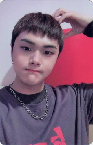 Photocard of Jahan making a bear ear on his head and puffing his face slightly