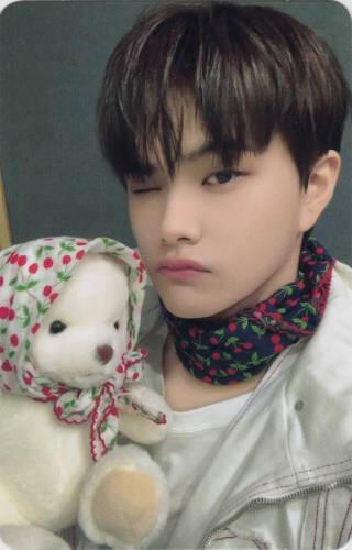 Photocard of Jahan wearing a scarf and winking while holding a teddy bear