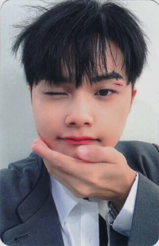 Photocard of Jahan cupping his chin and winking with a cut on his eyelid
