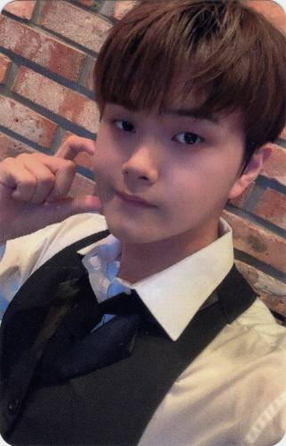Photocard of Jahan in a barista outfit making a half heart against his cheek