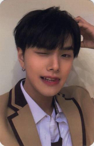 Photocard of Jahan wearing a tan blazer and making a bear ear on his head, winking, and biting his tongue
