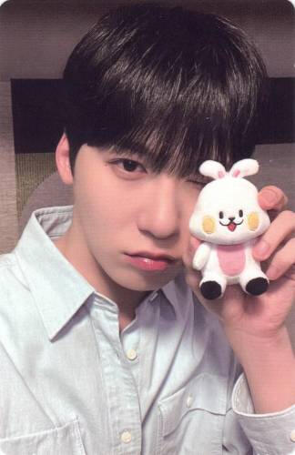 Photocard of Keonhee holding his representative bunny plush by his face