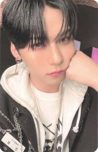 Photocard of Keonhee holding a fist to his cheek