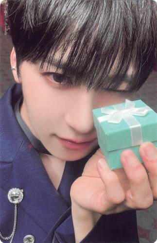 Photocard of Keonhee holding a small blue gift box to his face