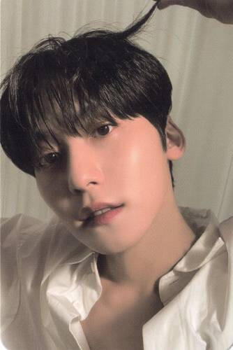 Photocard of Keonhee wearing an unbuttoned white shirt, holding a piece of his hair