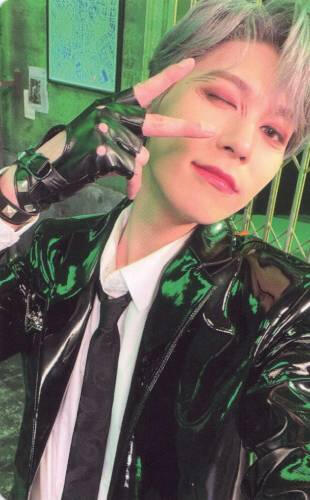 Photocard of Keonhee wearing a black vinyl jacket and fingerless leather gloves holding a peace sign by his eye and winking