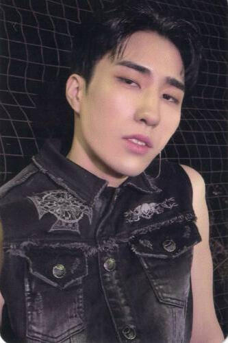 Photocard of Harin wearing a black denim vest and looking into the camera
