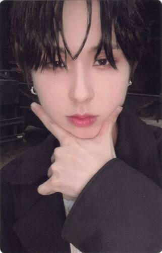 Photocard of Giuk making a check symbol under his chin and staring at the camera