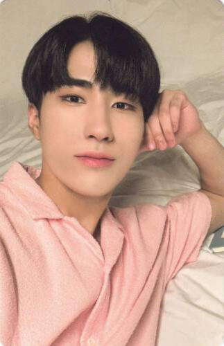 Photocard of Harin laying back and resting his head on his fist