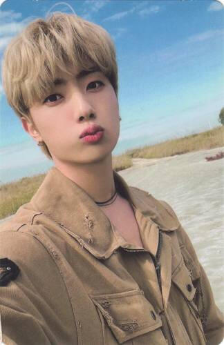 Photocard of Kanghyun making a kissy face in the desert