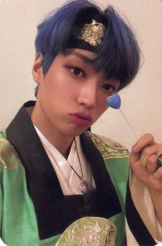 Photocard of Arthur wearing hanbok, holding a blue heart-shaped lollipop by his face