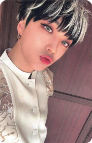 Photocard of Arthur wearing a white and gold outfit and making a kissy face
