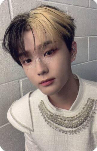 Photocard of Chiwoo wearing a white royal outfit with silver details and glitter on the bridge of his nose, staring at the camera+