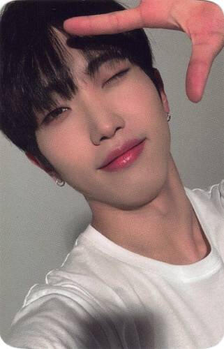 Photocard of Dann winking and holding a splayed hand by his face