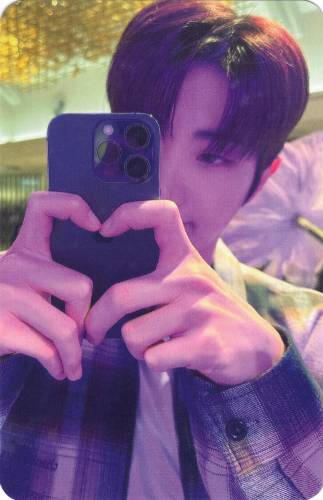 Photocard of Dann taking a mirror selfie with his fingers in a heart shape