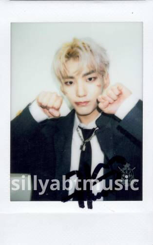 A signed polaroid of Hwon holding fists by his cheek