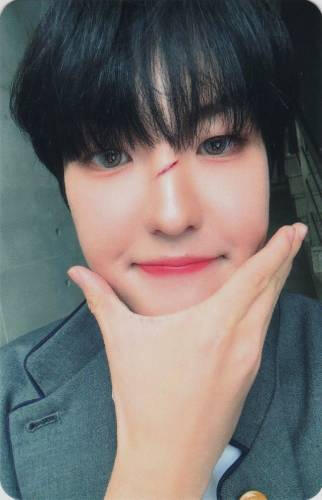 Photocard of Louis cupping his chin with a cut on his nose