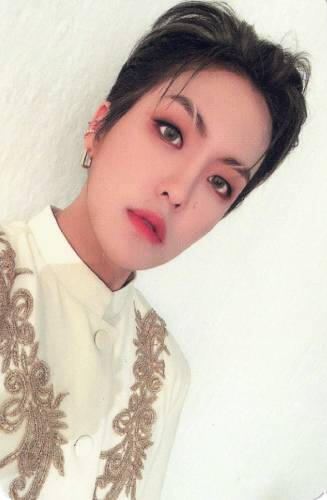 Photocard of Louis wearing a white outfit with gold detailing, staring at the camera