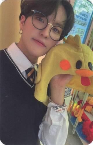 Photocard of Louis holding a duck hat up and smiling