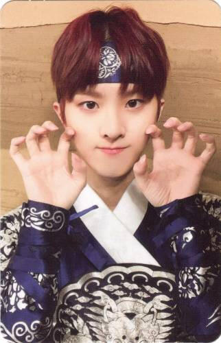 Photocard of Ivan wearing an ascension outfit and making two clawed hands by his face
