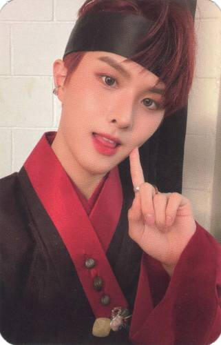 Photocard of Ivan in red hanbok poking his cheek and sticking his tongue out