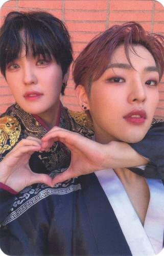 A photocard of Louis wrapping his arms around Mujin and making a hand heart
