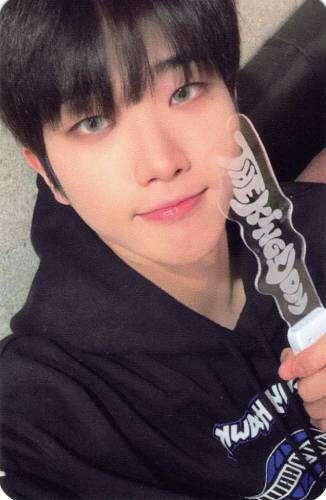 Photocard of Dann holding the Realize lightstick, wearing a black hoodie, and smiling