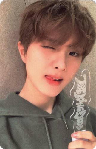 Photocard of Ivan wearing a green hoodie and winking while holding the Realize lightstick