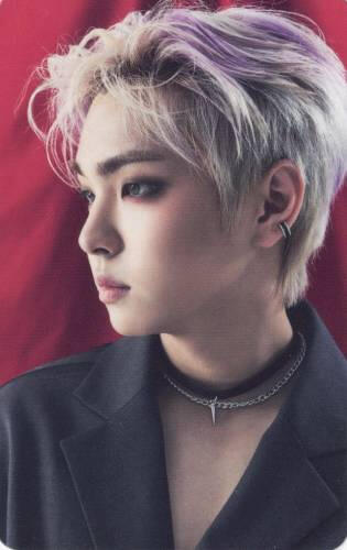 Photocard of the side profile of Kangsung from Ghost9, he's wearing a black suit jacket and choker, posed in front of a red curtain