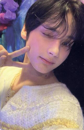 Photocard of Hueningkai from TXT wearing a fuzzy white sweater and making a peace sign