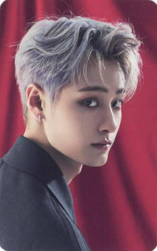 Photocard of Woojin from Ghost9 wearing a black suit jacket and gazing back towards the camera, posed in front of a red curtain