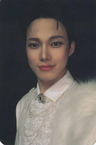 Photocard of Seungyeop from E'last wearing an intricate white button up and fluffy shoulder piece, staring into the camera