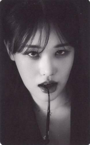 Photocard of a member of Craxy holding a glasses leg in her mouth