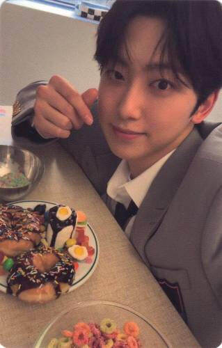 Photocard of Fuma making a finger heart while leaned over a plate of pastries