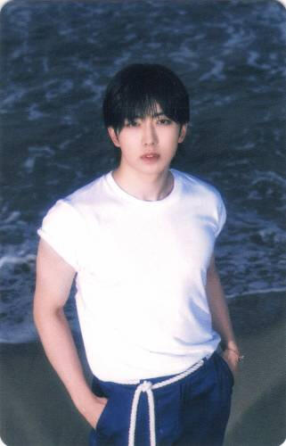 Photocard of Fuma standing on a beach with his hands in his pockets