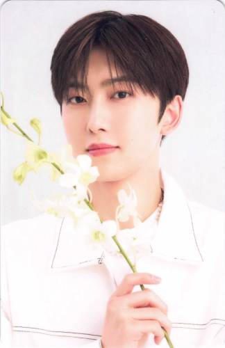 Photocard of Fuma standing with a white flower
