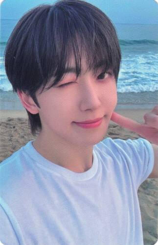 Photocard of Fuma poking his cheek on a beach