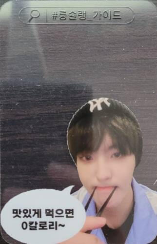 A photocard insert with Louis holding chopsticks in his mouth in the corner