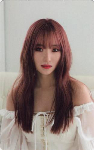 Photocard of Sua wearing an off the shoulder white dress, staring at the camera