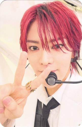 Photocard of Yuta with red hair and a microphone making a peace sign