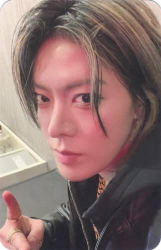 Photocard of Yuta wearing a black hoodie and making a peace sign